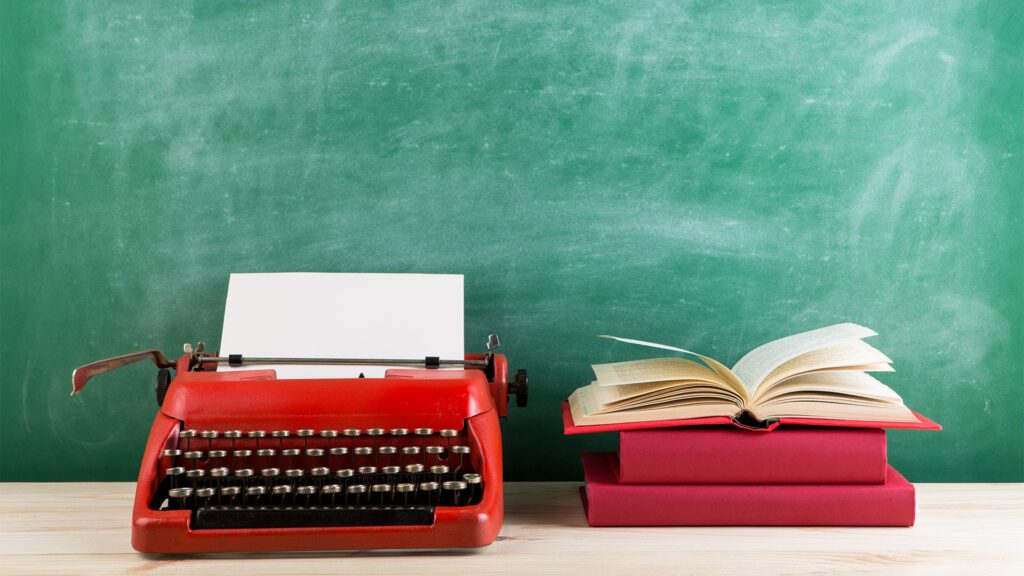 typewriter next to a stack of books