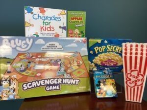 Prize bundle with Charades for Kids, Apples to Apples Junior, Bluey Scavenger Hunt Game, Disney Eye Found It, and Pop Secret popcorn with serving buckets