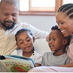 African American family of four happily reading together