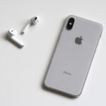 An iPhone and AirPods lying on a flat surface